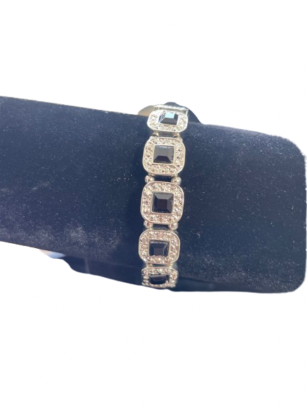 Silver bracelet with square links on a black cushion