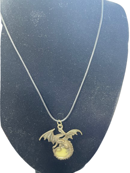 Gold dragon pendant necklace on a dark stand