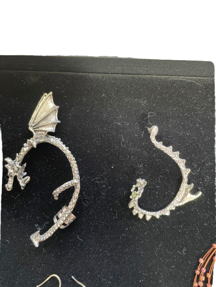 Dragon-shaped earrings on a black card