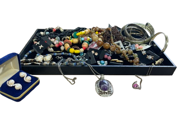 Assorted jewelry on a black tray with a white background