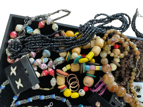 Assorted necklaces with beads and charms on a black tray