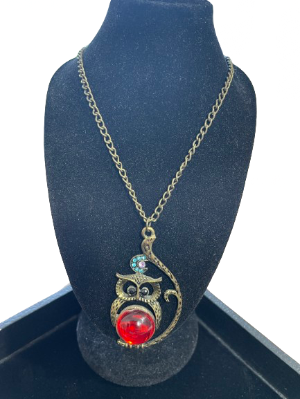 Necklace with an owl pendant on a black stand