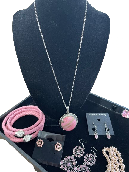 Jewelry set including a necklace, bracelets, earrings, and rings on a black display stand.