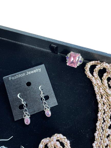 Jewelry set with pink gemstone earrings on a black display card.