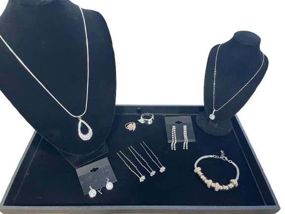 Jewelry set on a blue tray with necklaces, earrings, and a bracelet displayed.