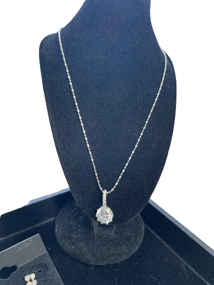 necklace on a blue velvet stand with a white background