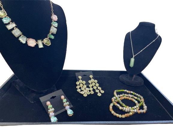 Jewelry set including necklace, earrings, and bracelet on a blue velvet display
