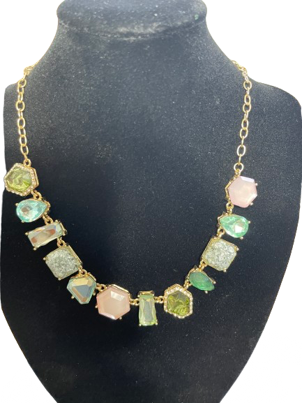 Necklace with colorful gemstones on a black mannequin bust