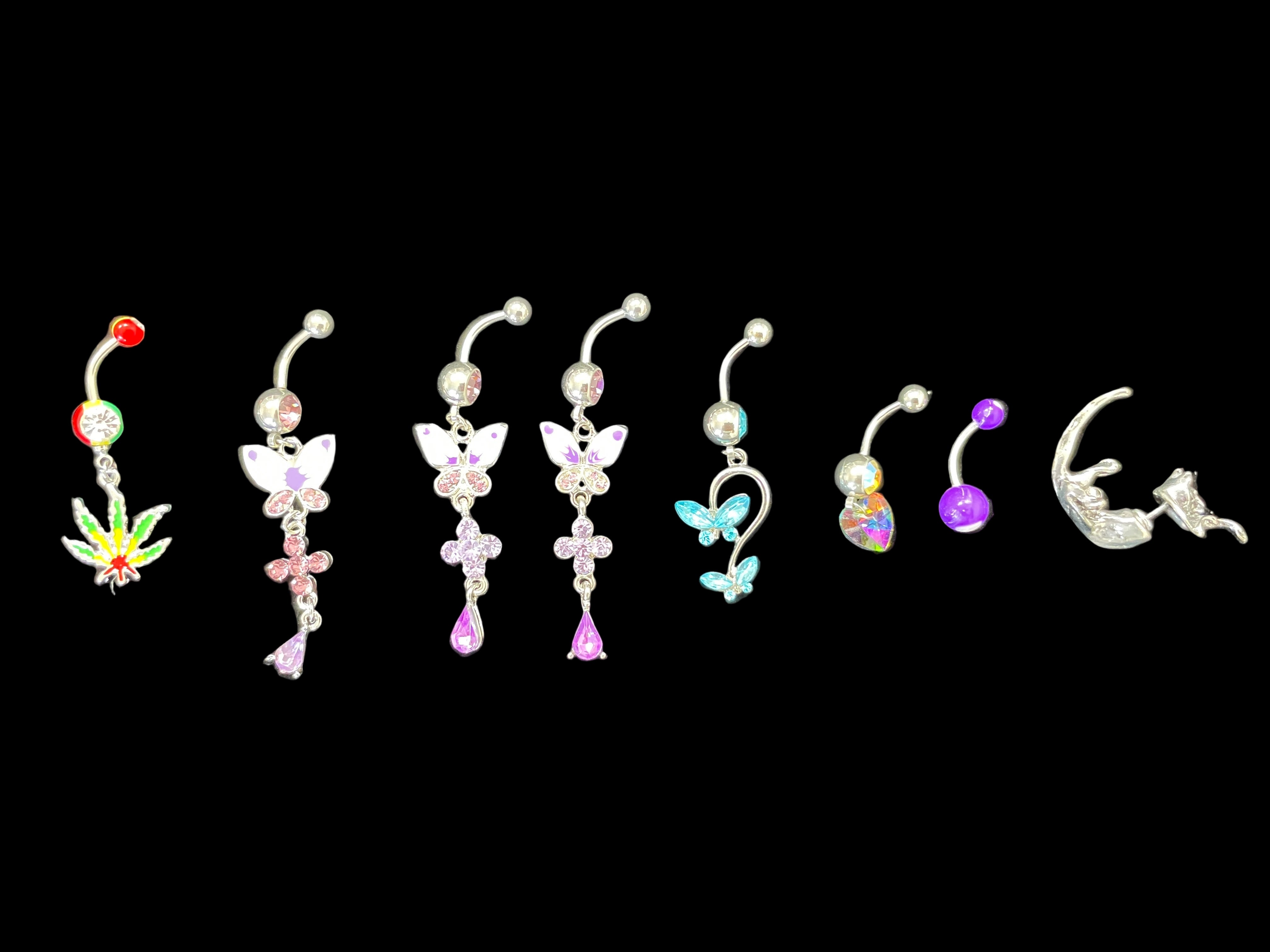 Set of colorful belly button rings on a dark surface