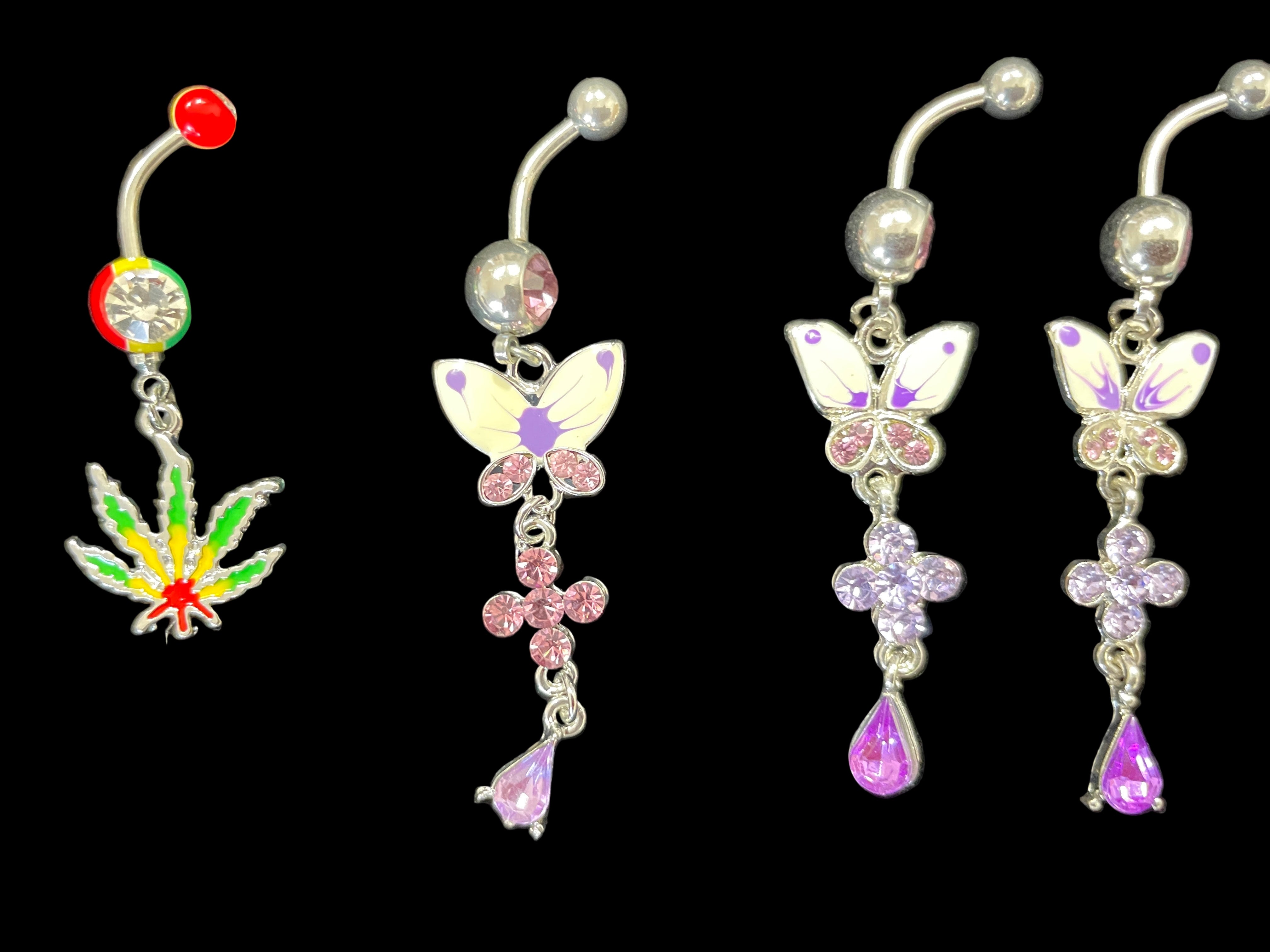 Set of four belly button rings with colorful designs on a black background