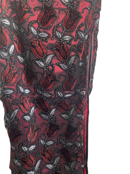 Close-up of a red fabric with black floral pattern on a white background