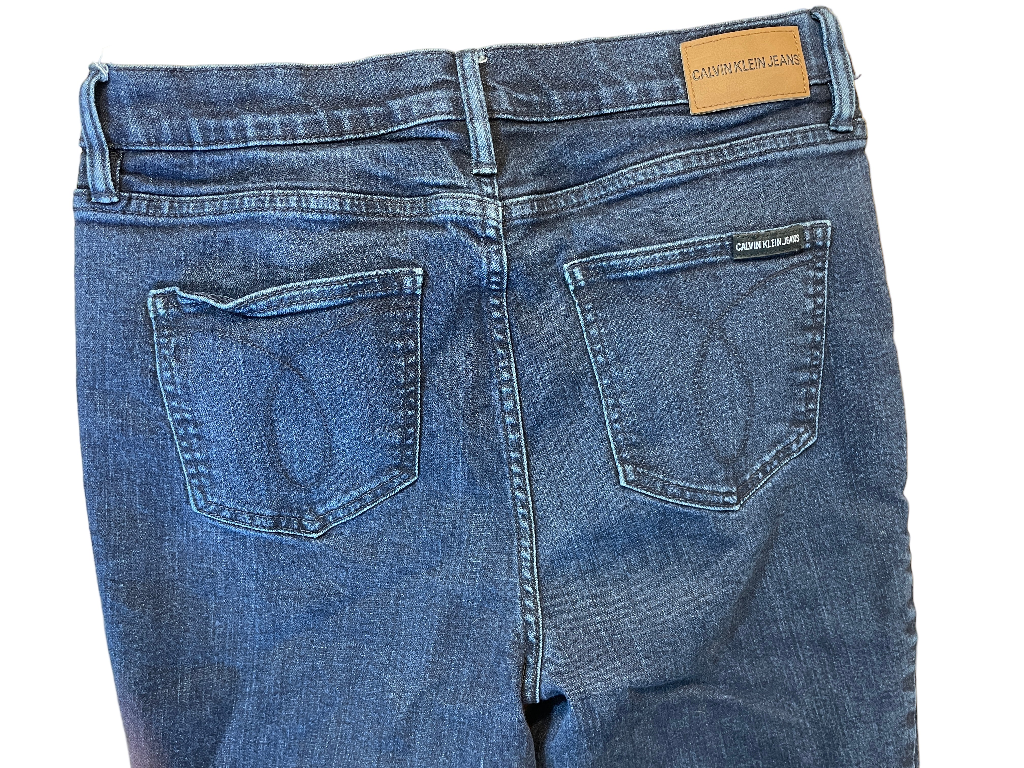 Back view of Calvin Klein dark wash skinny jeans with stitched pockets and logo patch