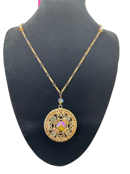 Gold-tone filigree pendant necklace with aurora borealis rhinestones on black bust
