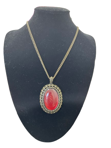 Necklace with a red pendant on a black mannequin bust