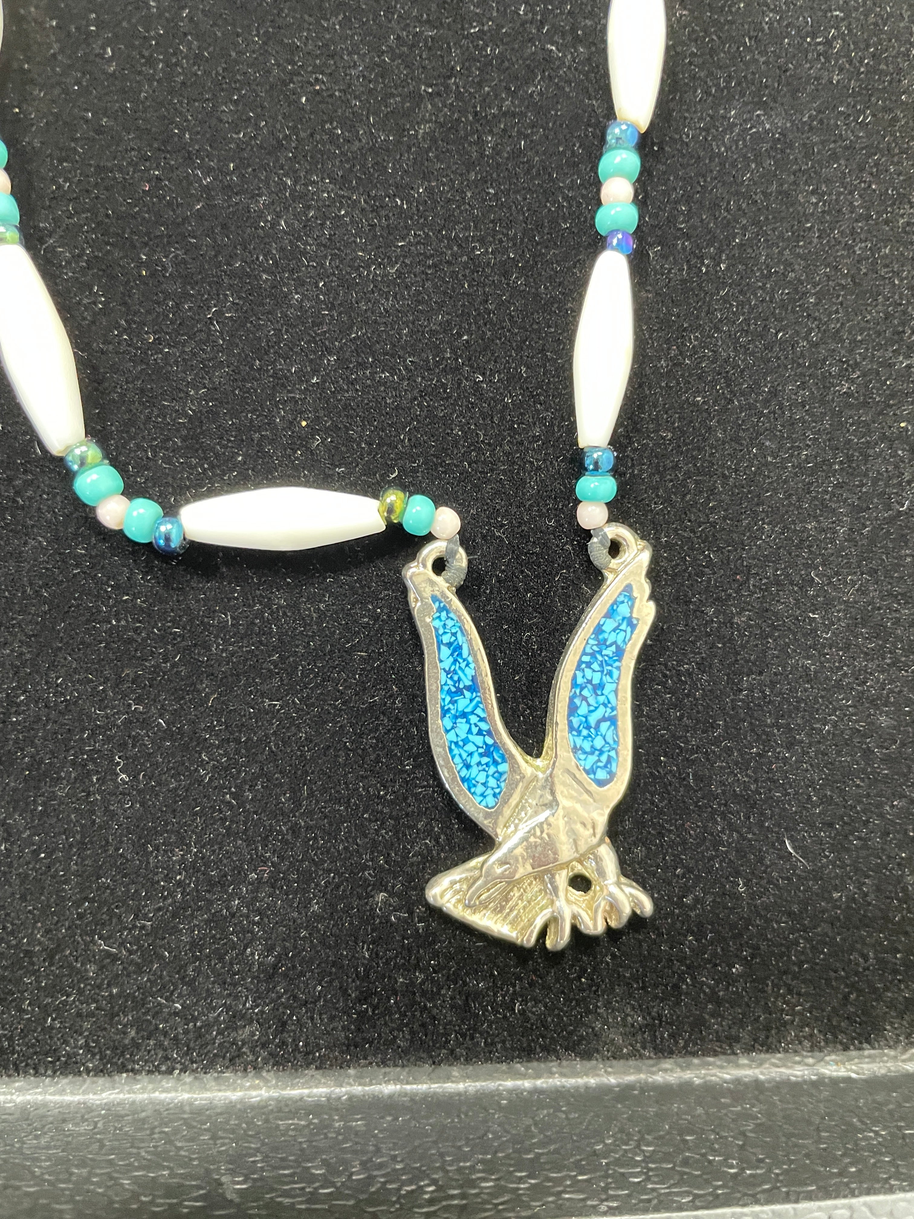 Necklace with a bird-shaped pendant on a dark background