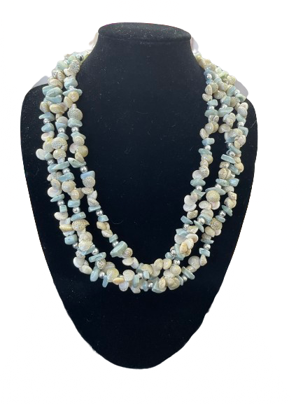 Necklace with blue and white beads on a black mannequin bust