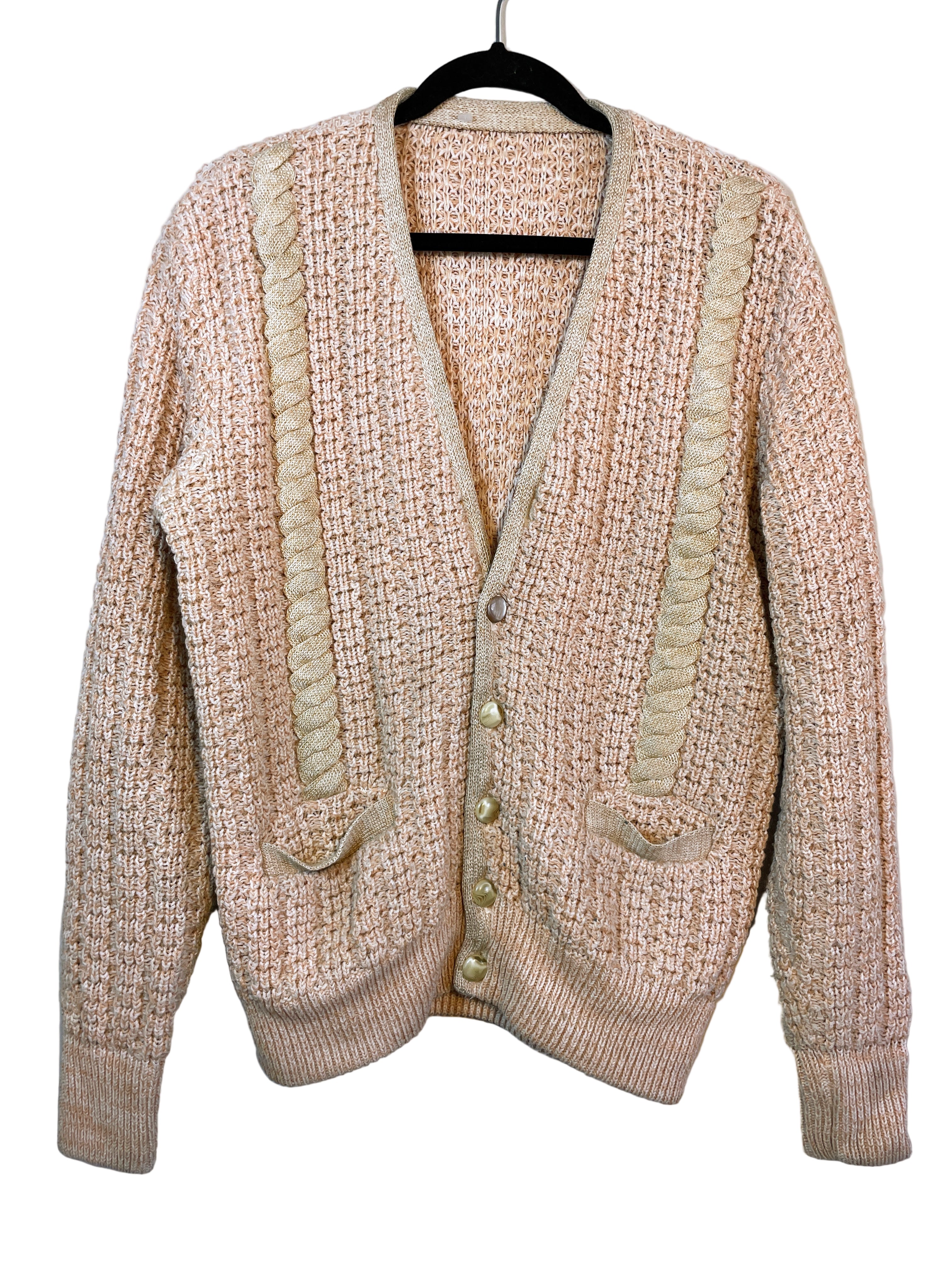 Front view of peach and beige knit cardigan with cable detailing and buttons.