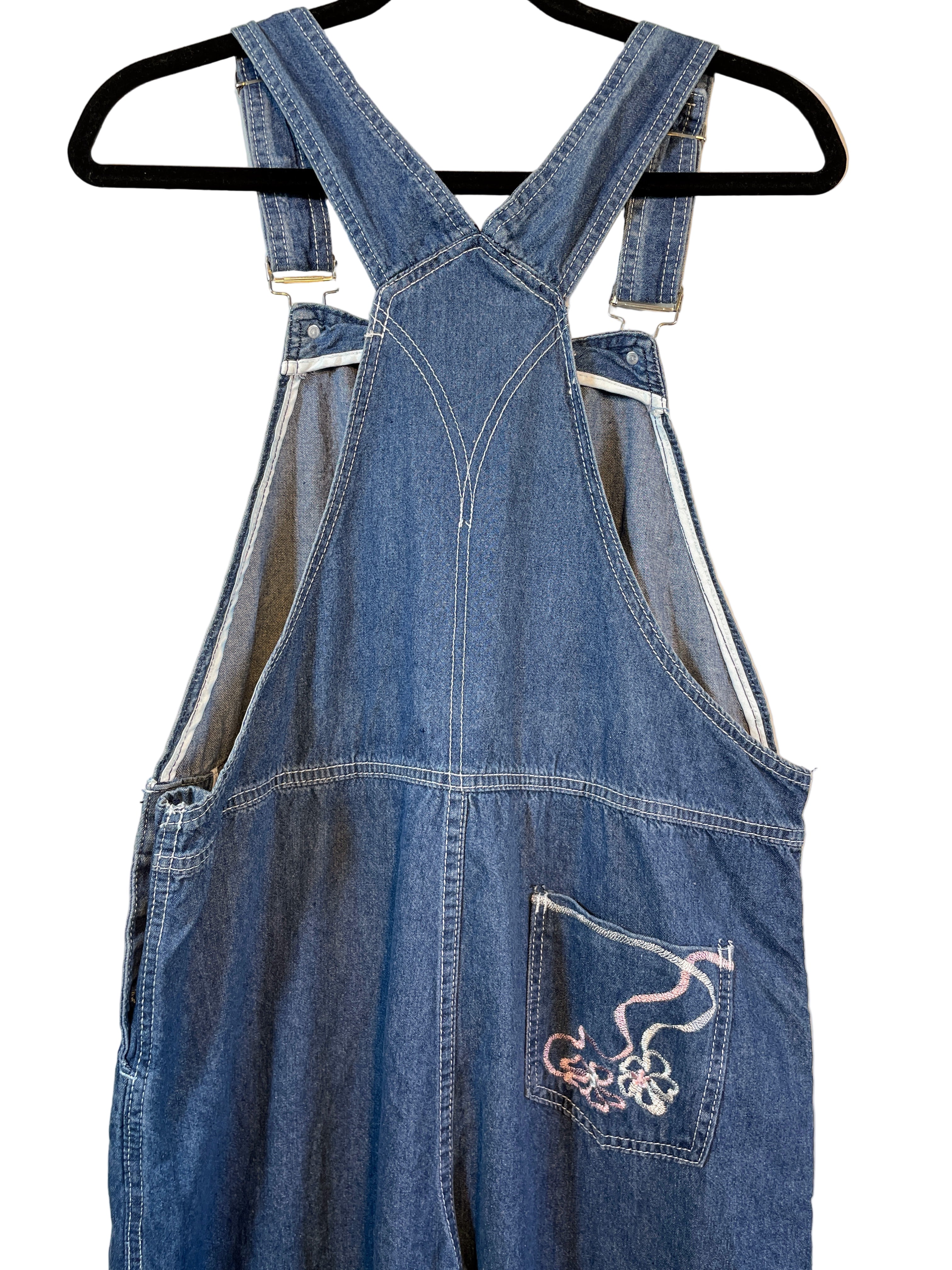 Back view showing cross-back strap detail and embroidery on pocket