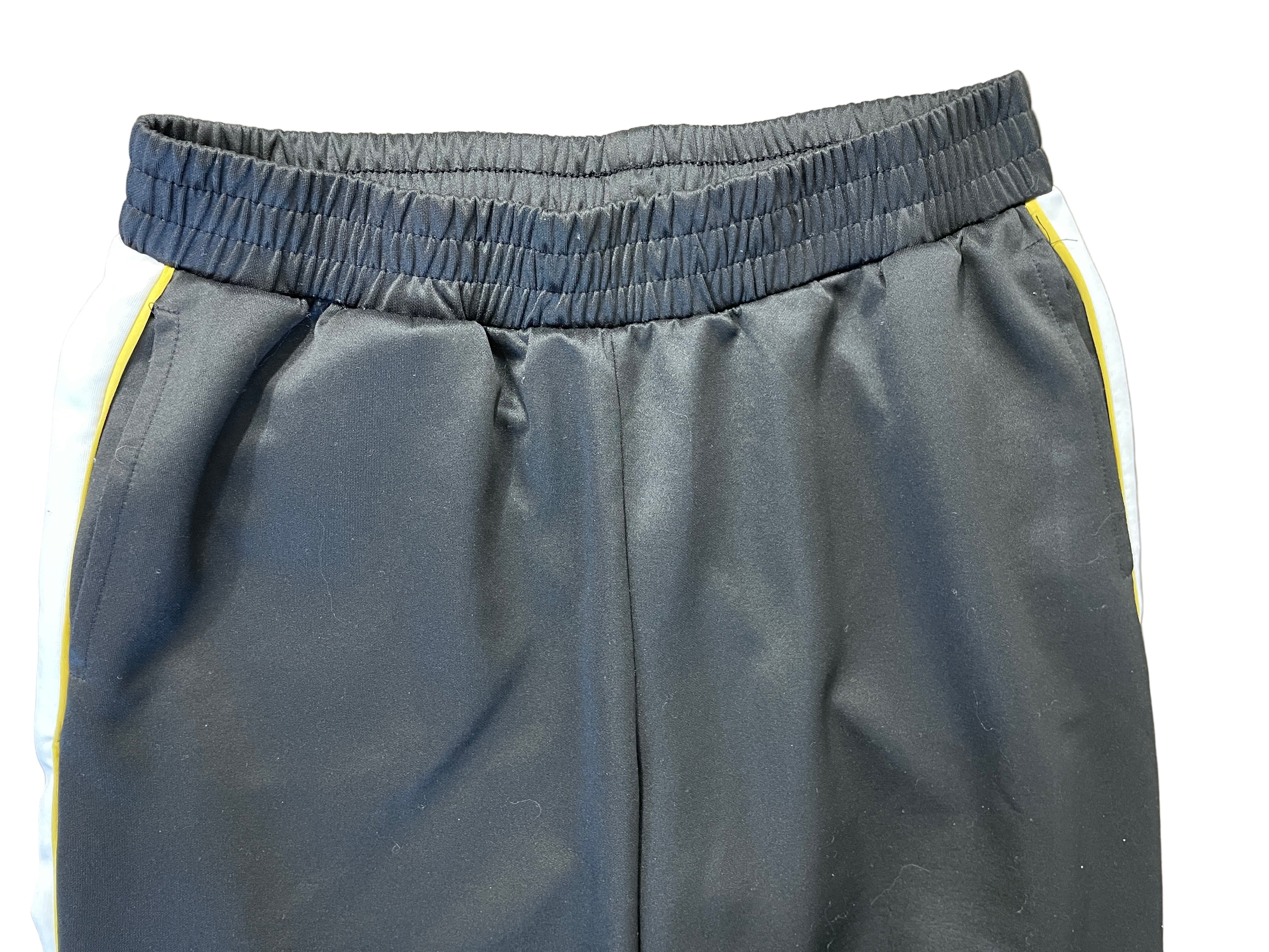 Front view of H&M Divided black track pants showing waistband, side pockets, and stripe design.