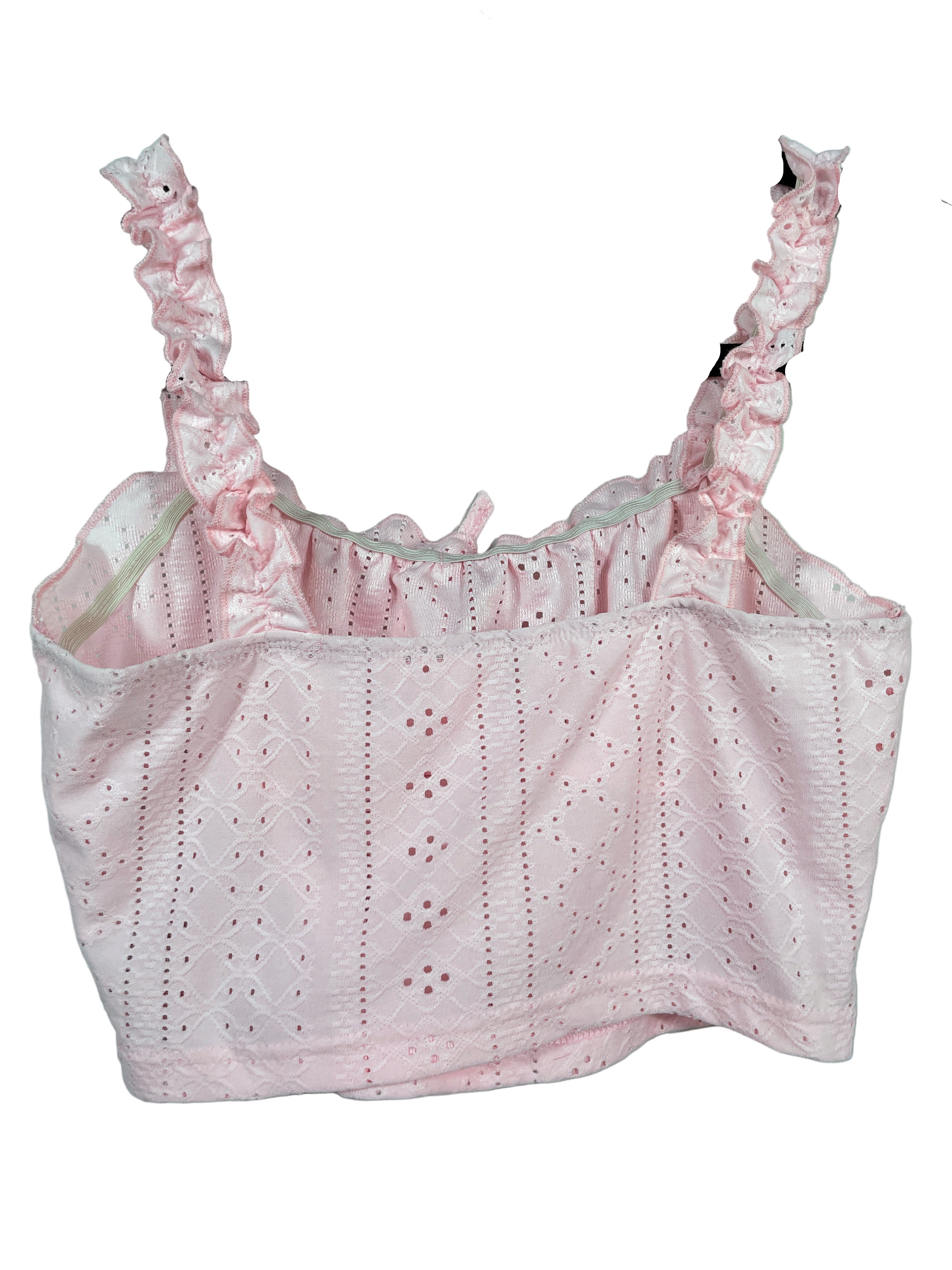 Pink lace top on a hanger against a light blue background