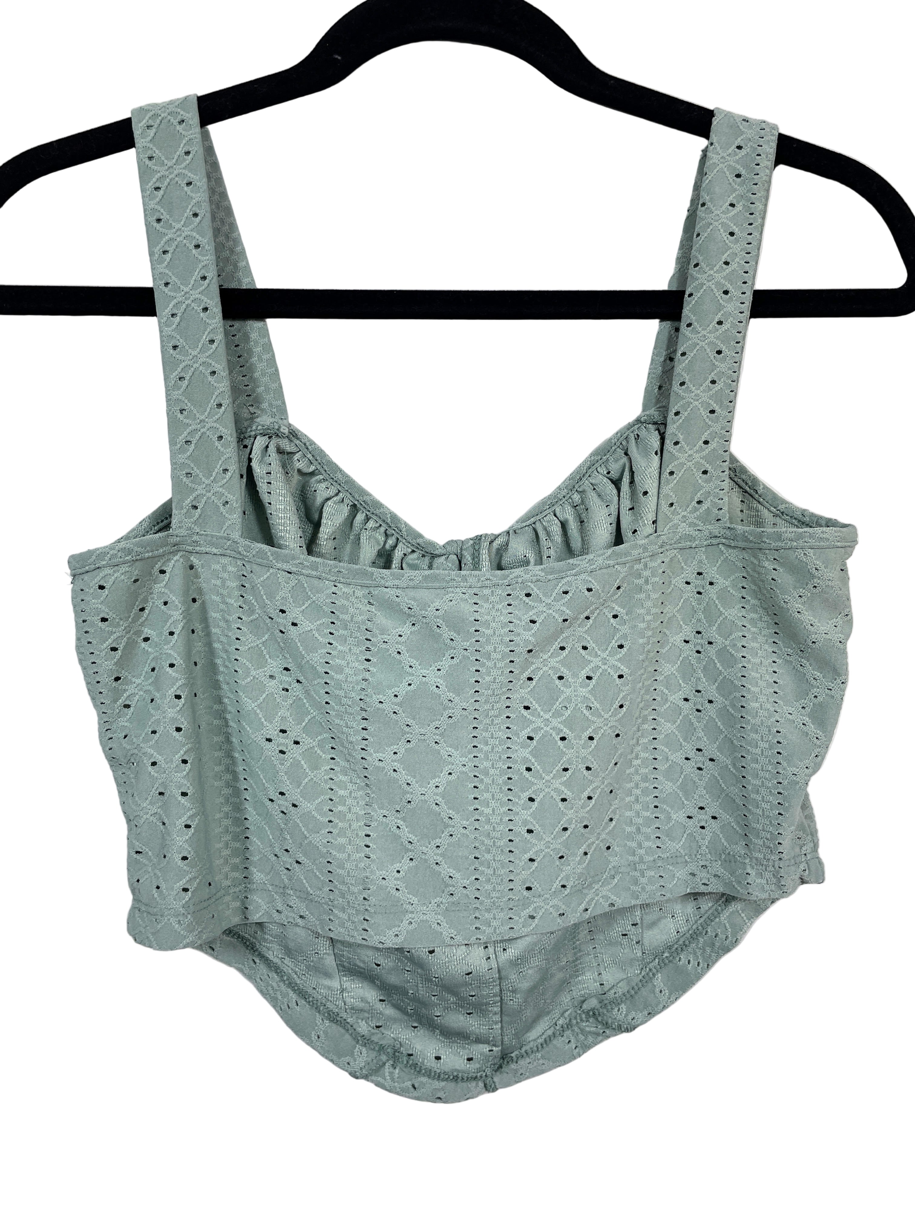 Green lace top and shorts set on a hanger against a white background