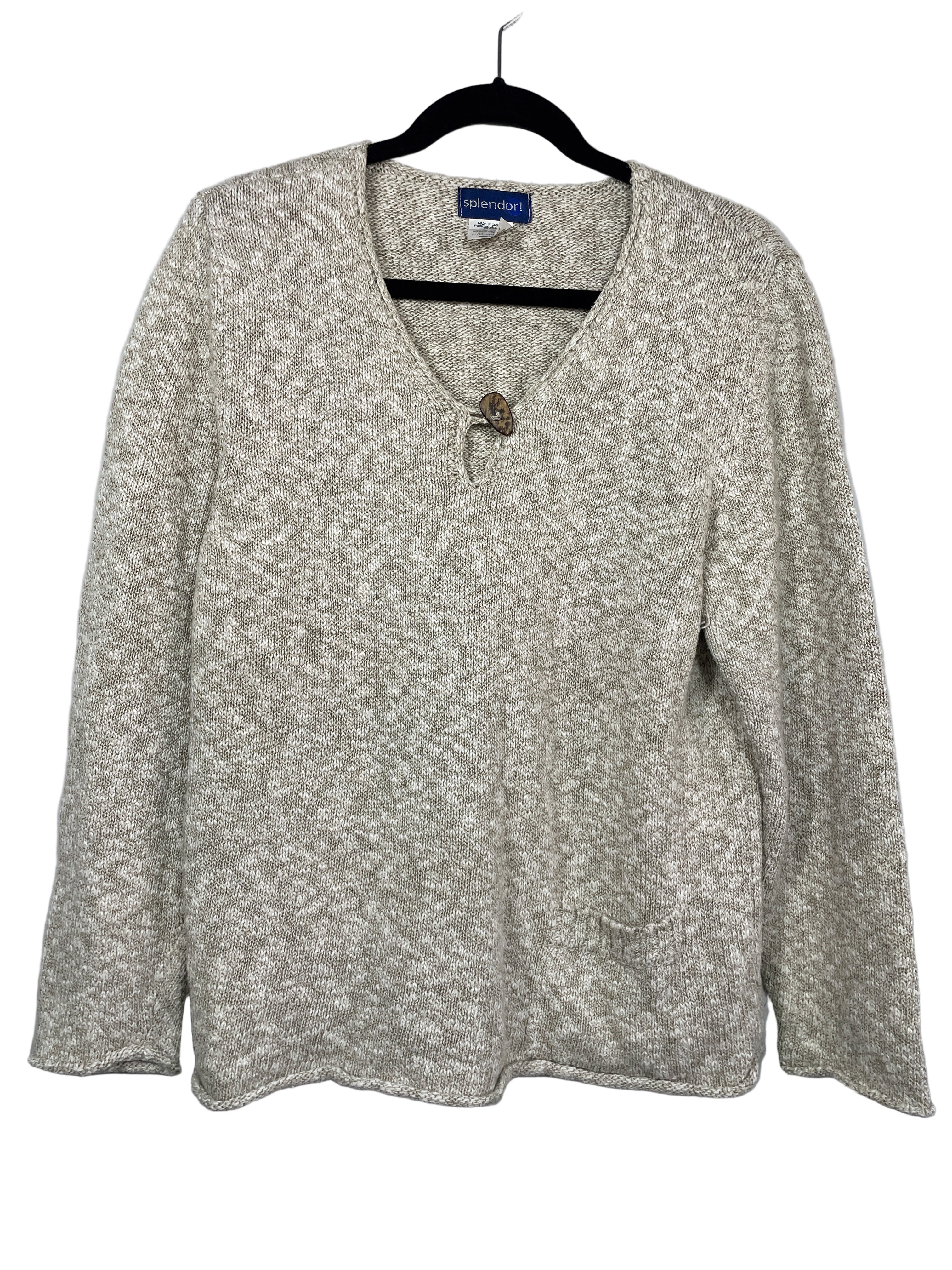 Front view of Splendor! beige and cream knit sweater with wooden button and front pocket.
