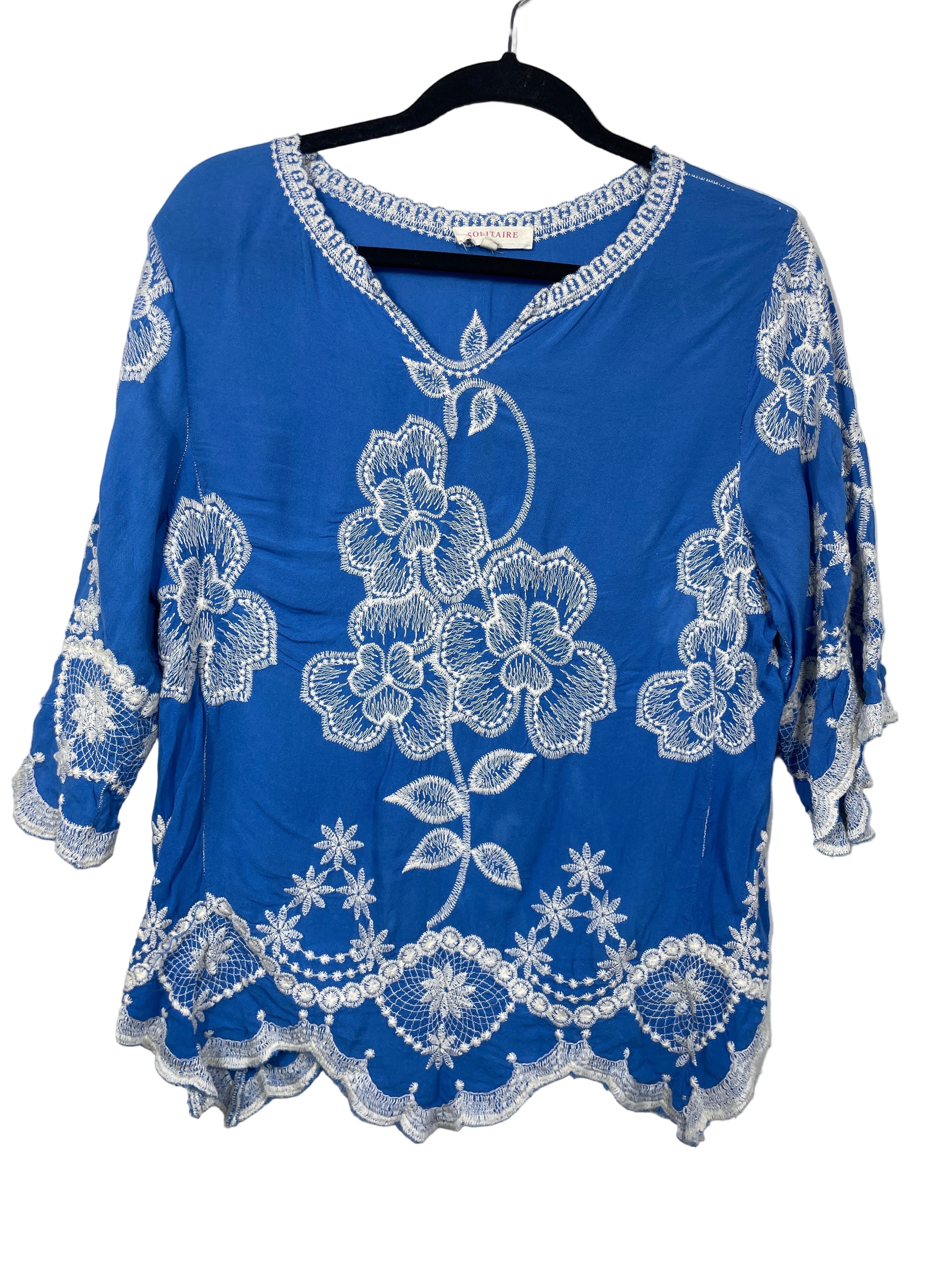 Solitaire blue embroidered boho top front view showing white floral embroidery and scalloped hem
