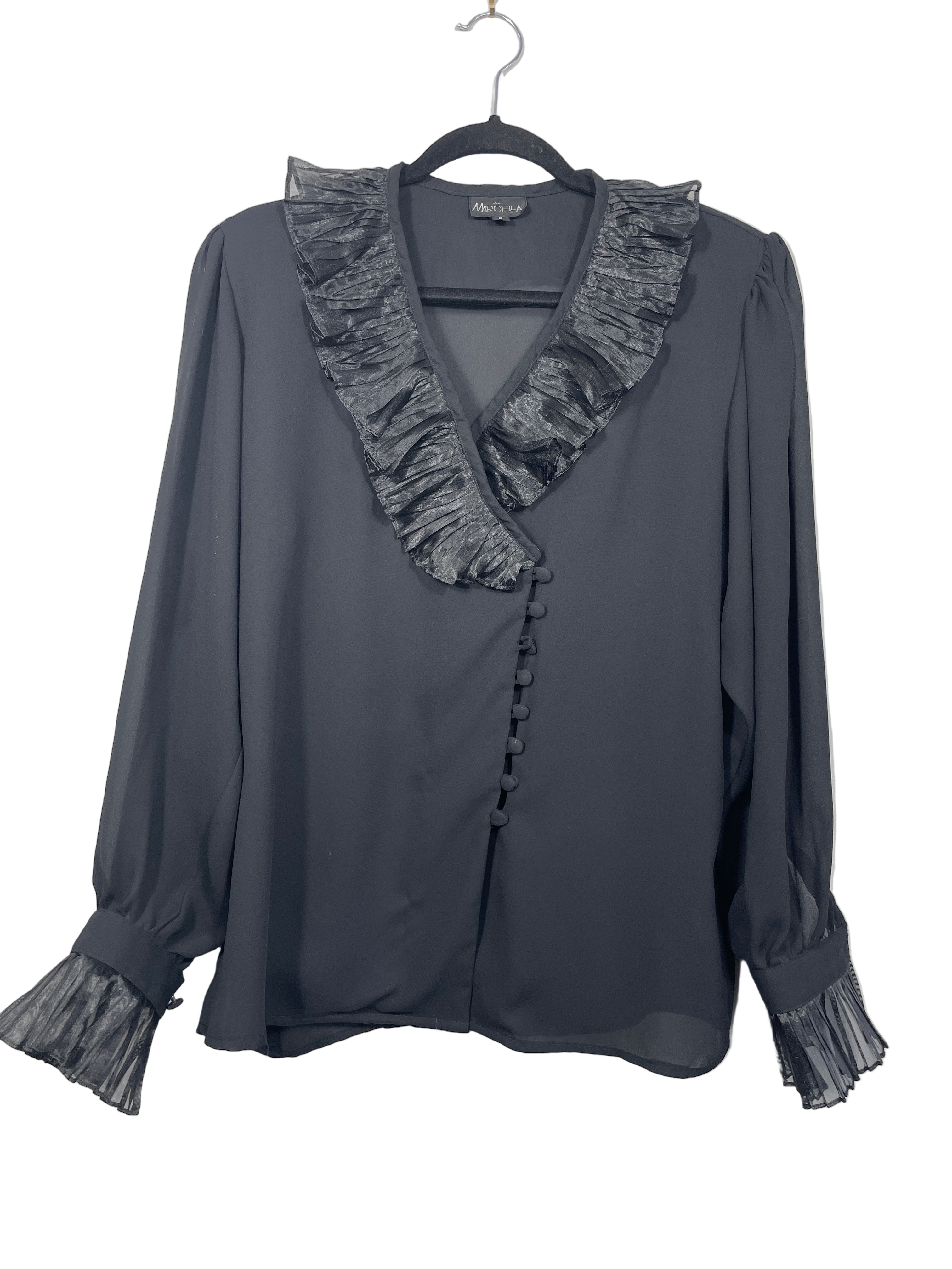 Marcella black blouse front view showing ruffled satin-look collar, covered buttons, and long sleeves with ruffled cuffs