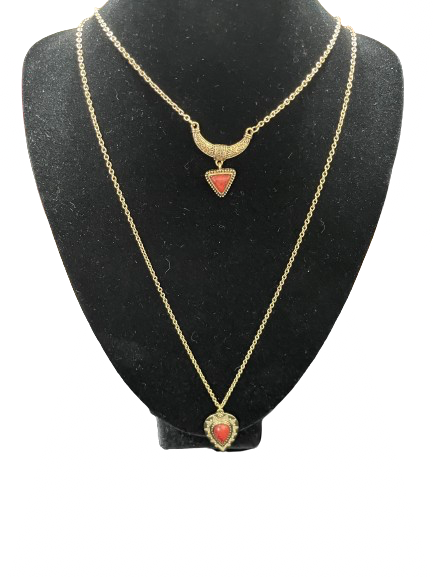 Two gold necklaces with heart-shaped red stones on a black mannequin bust.