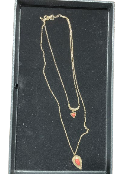 Gold necklace with heart pendants on a black display box