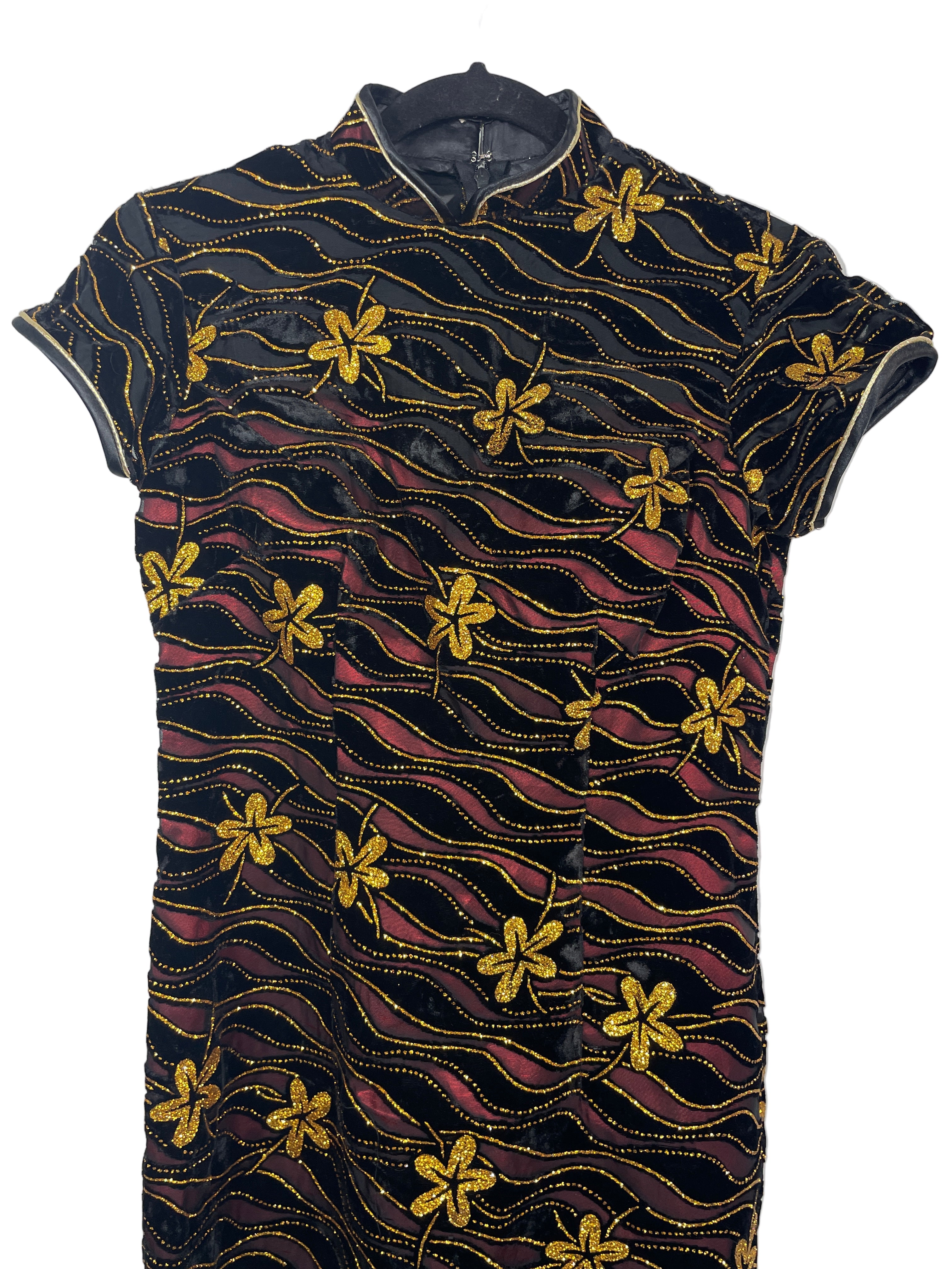 Xiangyi Qipao close-up showing gold embroidered flowers and collar detail.

