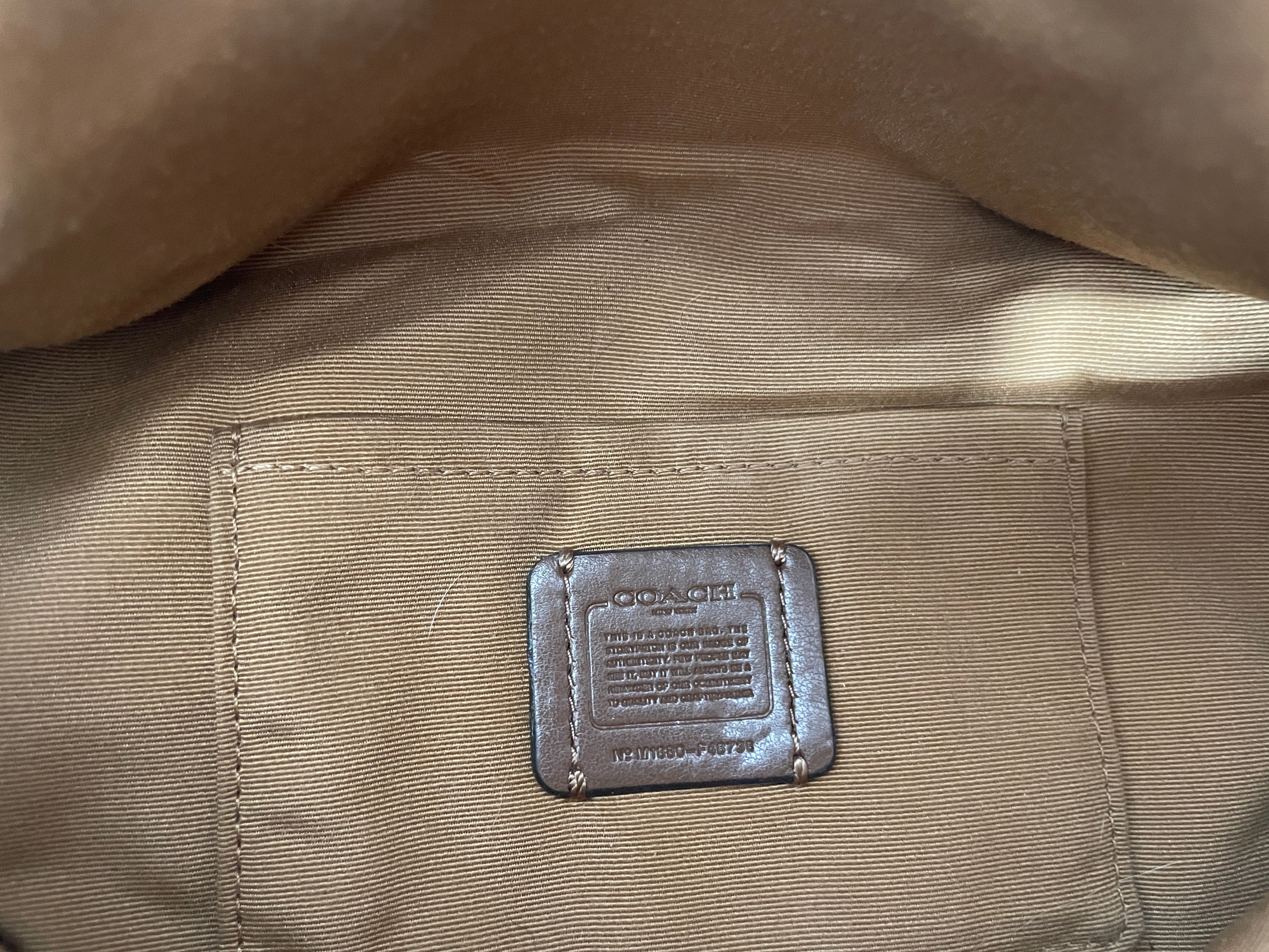 Close-up of a Coach label on a brown fabric surface
