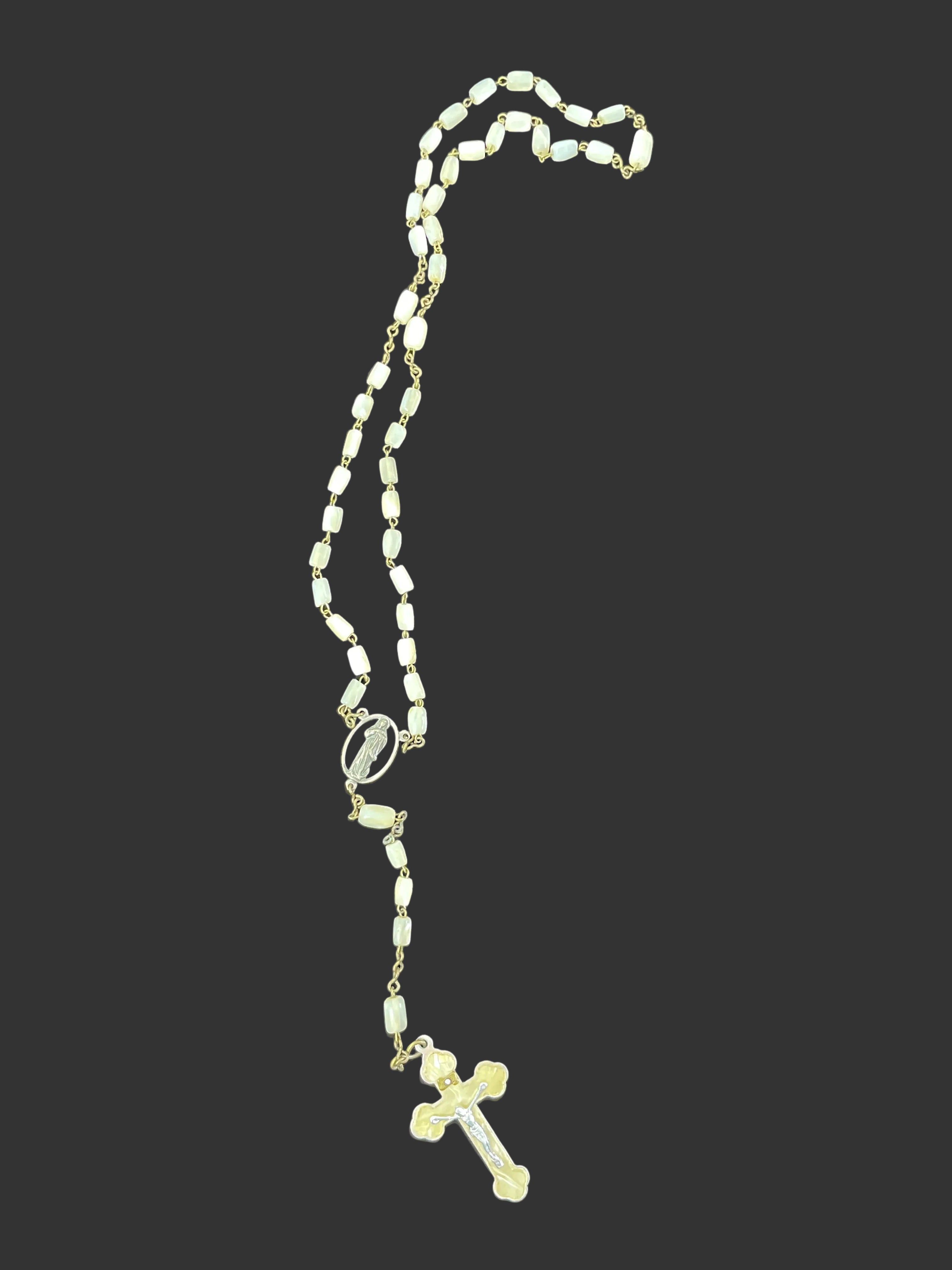 Long crucifix style costume necklace laid flat showing full length, centre medallion, and drop detail