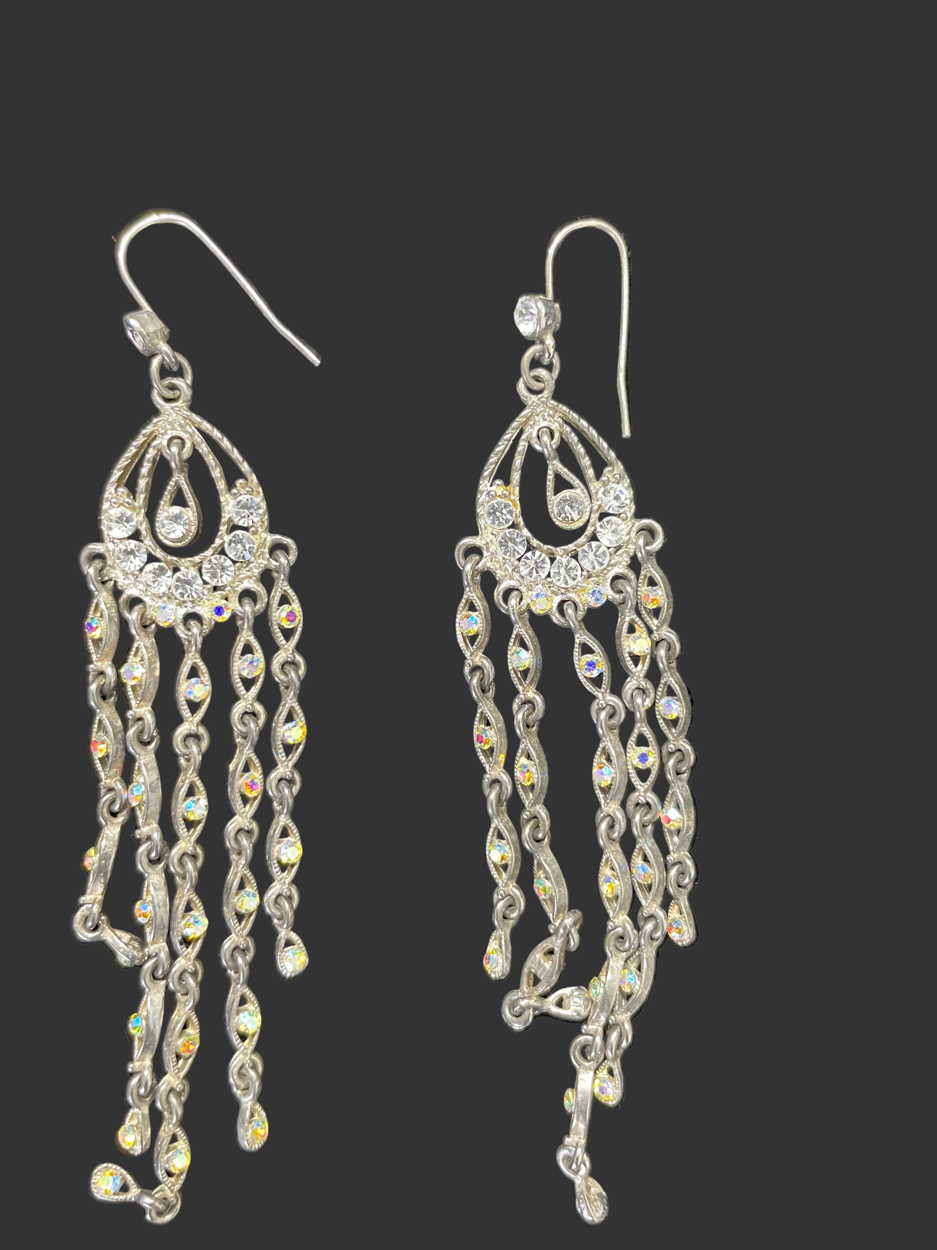 Silver tone rhinestone chandelier drop earrings shown flat on black background