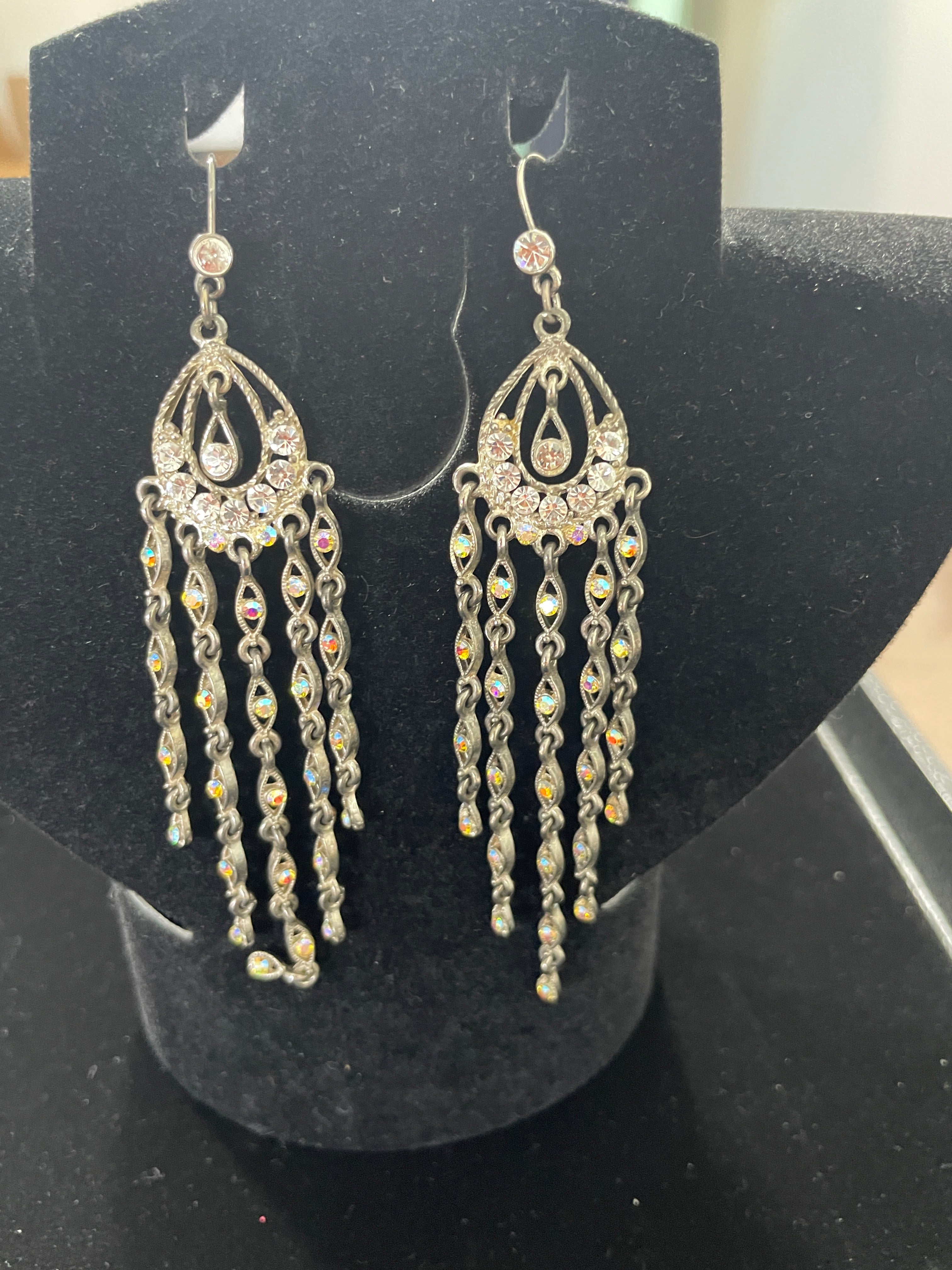 Silver tone rhinestone drop earrings displayed on black jewellery stand showing full length