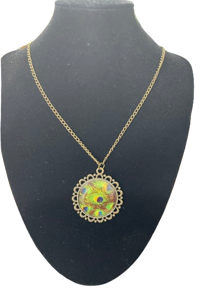 Gold tone peacock feather style glass pendant necklace displayed on black bust