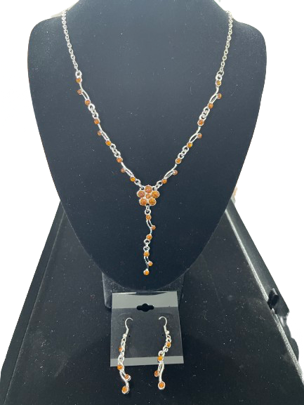 Silver tone amber rhinestone necklace and earrings set displayed on black jewellery bust