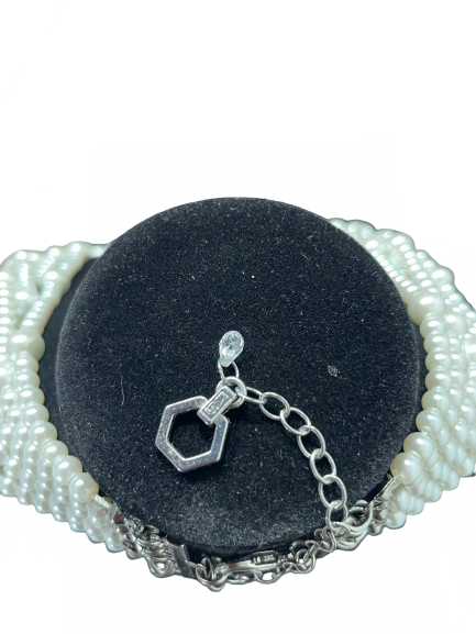 Detail of necklace clasp, extender, and faux pearl strands