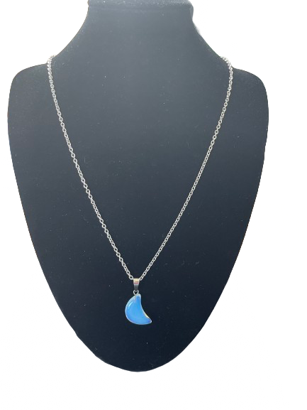 Front view of translucent crescent moon pendant necklace appearing blue on black bust
