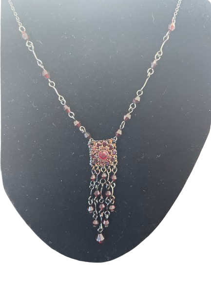 Close up of rhinestone centre station with burgundy bead fringe on necklace