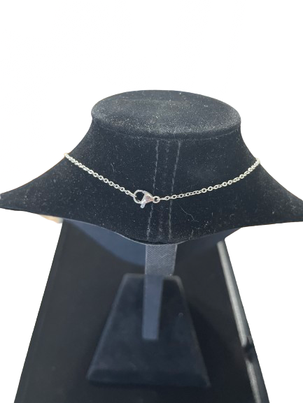 Silver chain necklace on a black mannequin bust with a white background