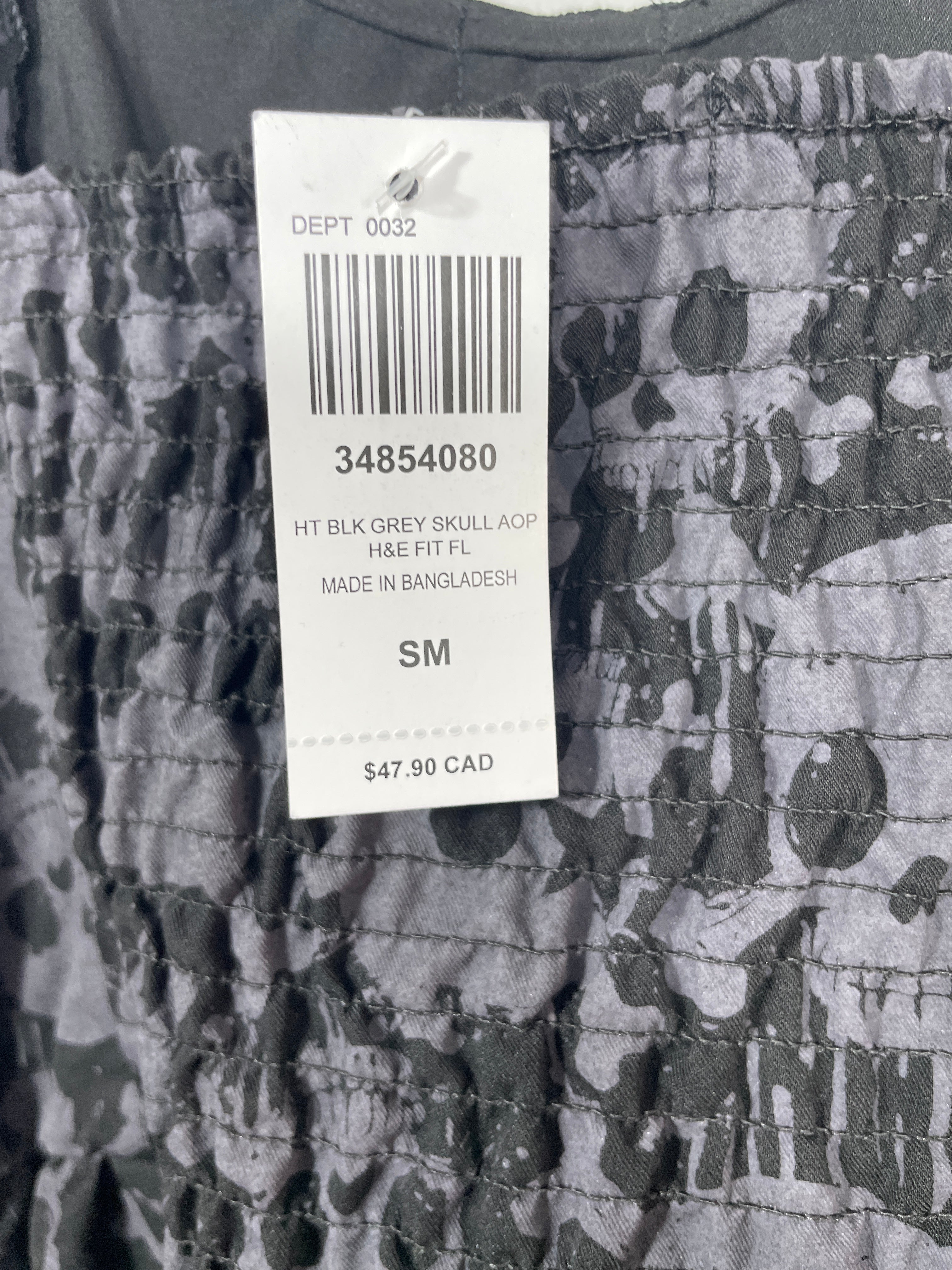 Camouflage-patterned fabric with a price tag displaying a barcode and text.