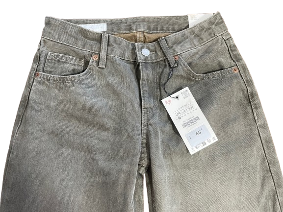 A pair of gray-wash denim jeans with a price tag attached, photographed flat against a white background.