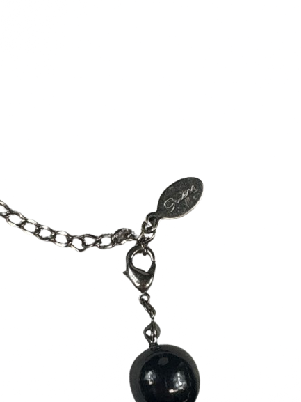 Close-up of Guess logo tag on necklace clasp