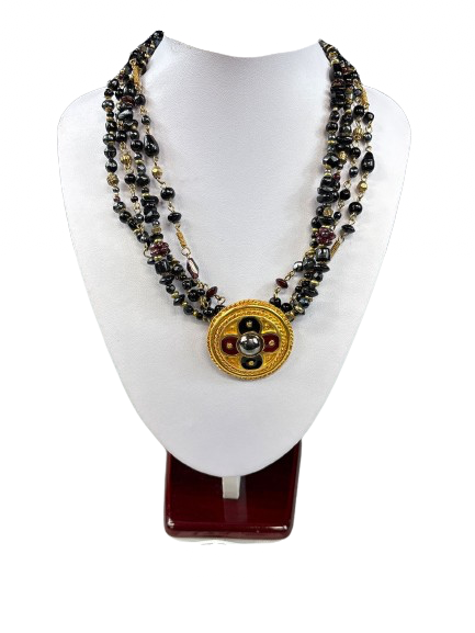Vintage multi-strand black and gold glass bead necklace on display stand